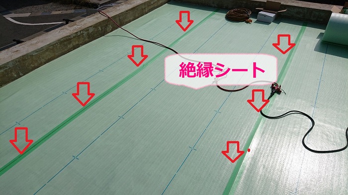 塩ビシート防水機械固定工法で絶縁シートを貼っている様子