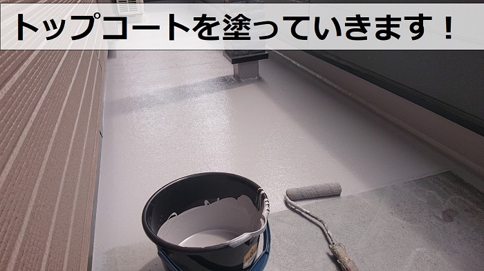 バルコニー防水工事でトップコートを塗っている様子