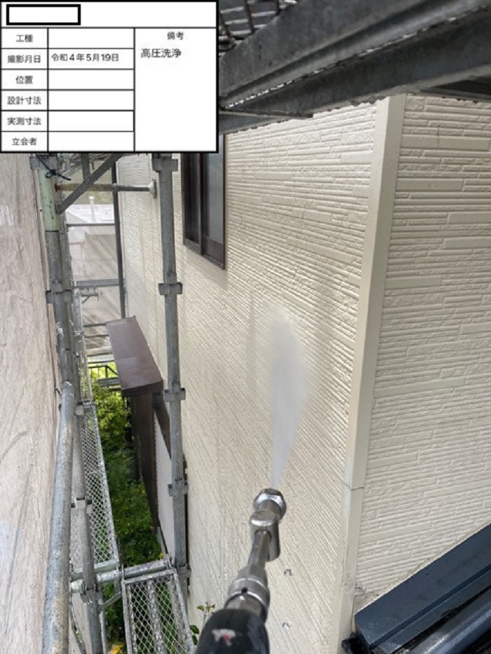 苔で汚れた外壁を高圧洗浄している様子