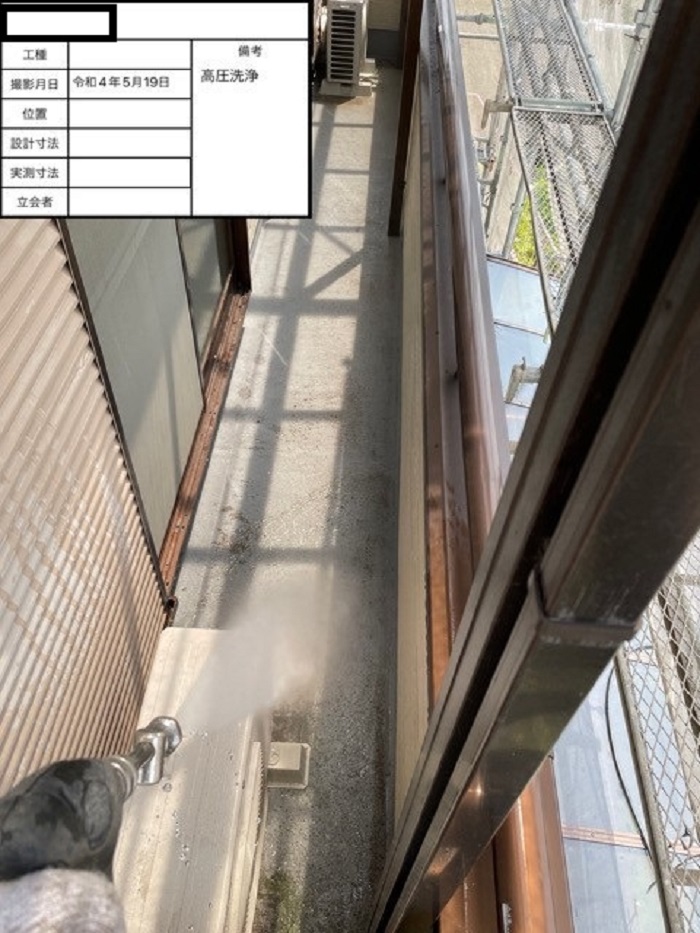 ベランダ床を高圧洗浄している様子