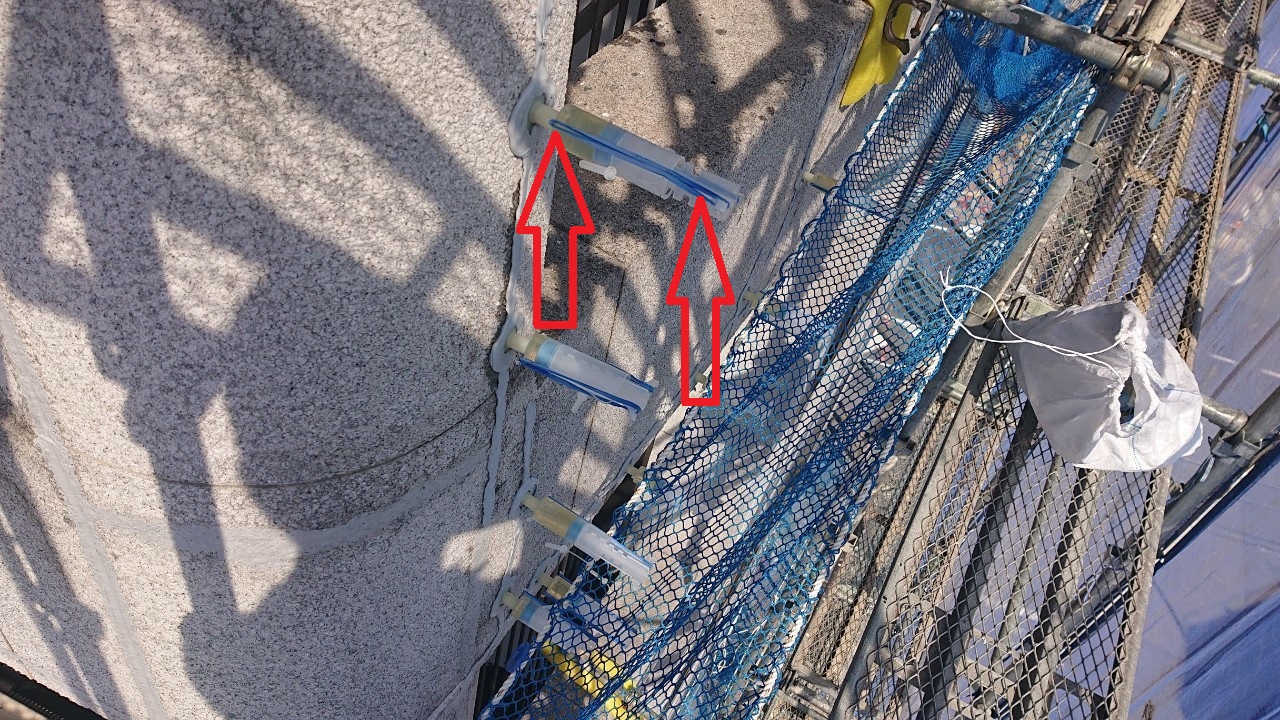 神戸市中央区の外壁補修で輪ゴムを用いて低圧注入している様子