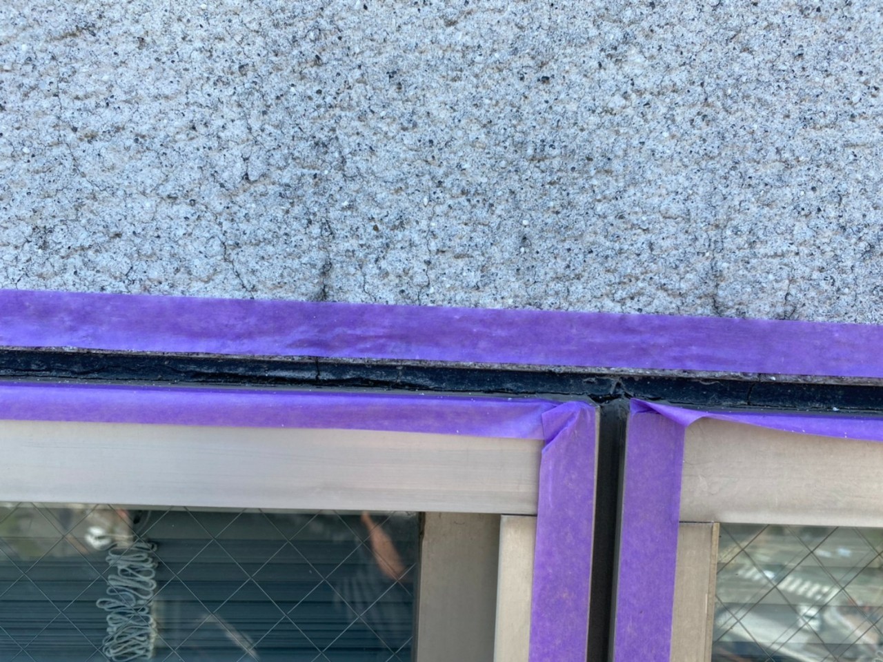 神戸市中央区でのコーキング打ち替え工事でサッシ廻りに養生している様子