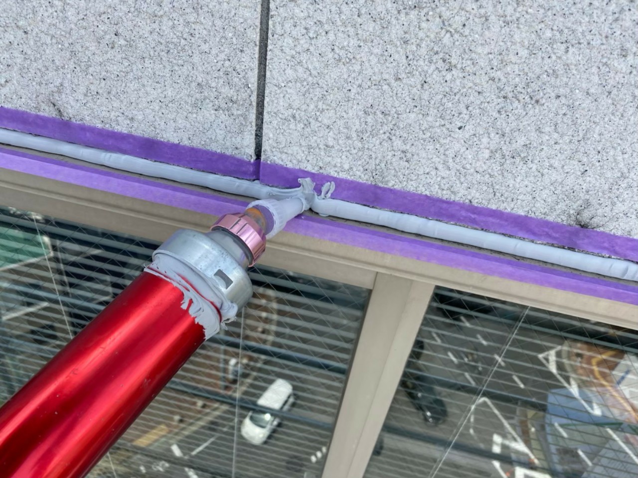 神戸市中央区でのコーキング打ち替え工事でコーキングを流している様子