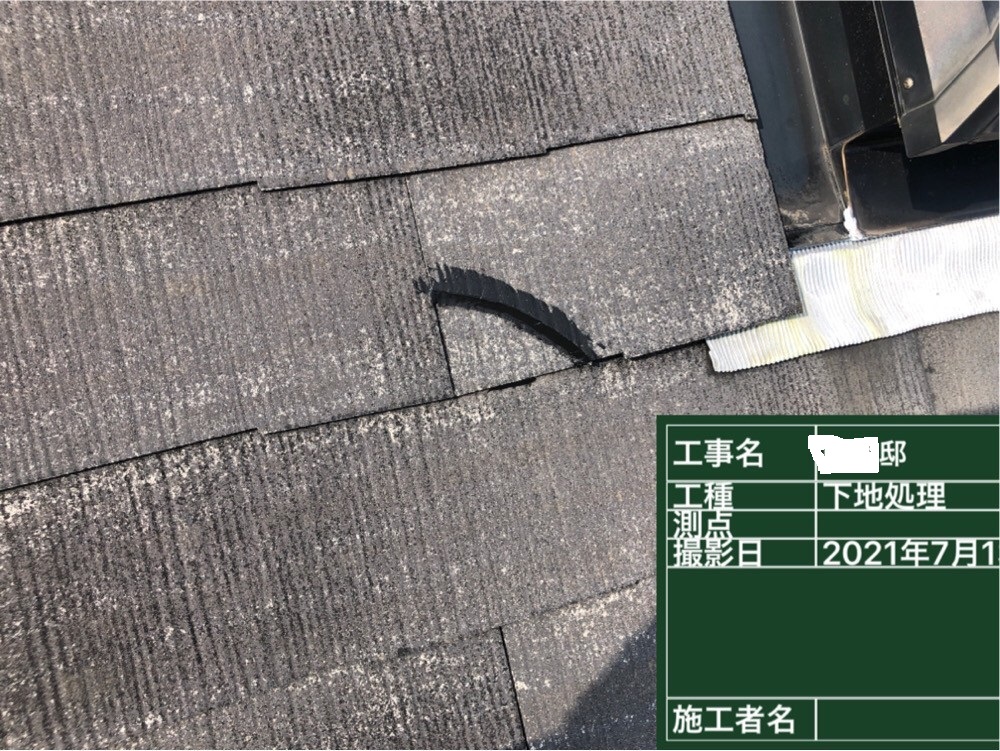 屋根塗装前にひび割れたスレート屋根を補修している様子