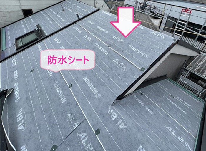 トップライト付きカラーベスト屋根のカバー工事で防水シートを貼っている様子