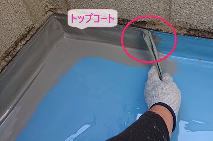 ベランダ床のウレタン防水通気暖衝工法でトップコートを塗っている様子