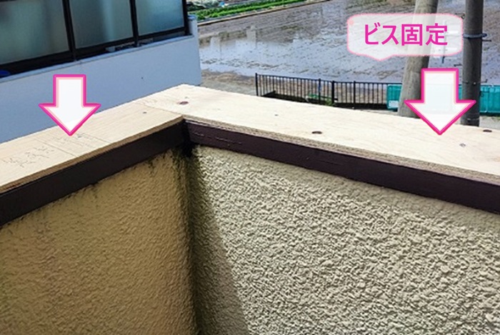 ベランダ腰壁上部の笠木メンテナンスで下地用合板をビスで固定している様子