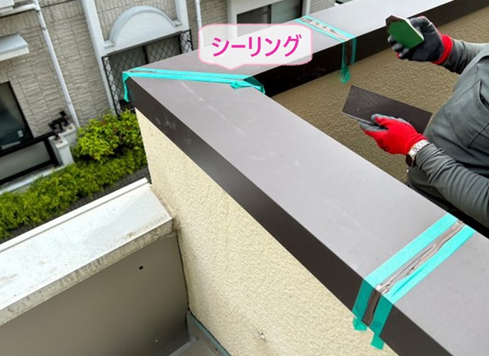 ベランダ腰壁上部の笠木メンテナンスの仕上げにシーリングを打っている様子