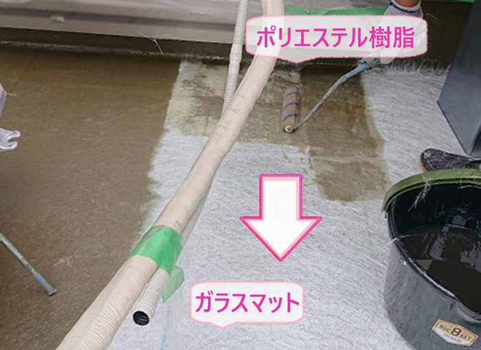 ベランダFRP防水工事でガラスマットを敷いてポリエステル樹脂を塗っている様子