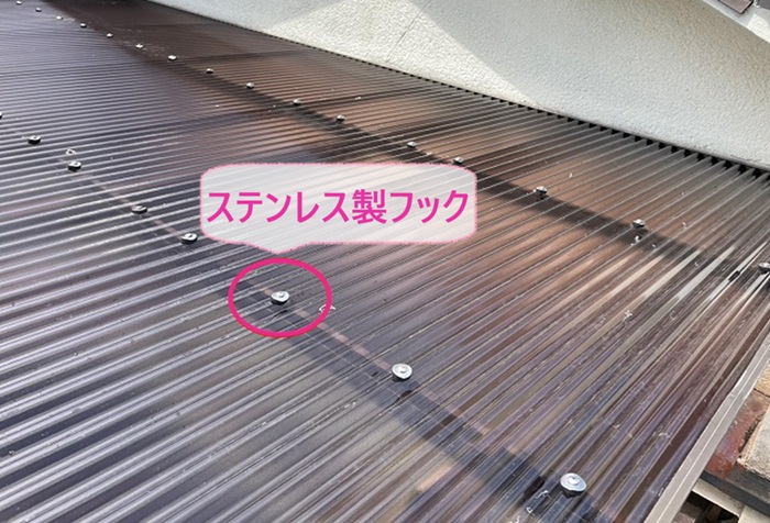 ２階バルコニー屋根の波板交換でポリカ波板をステンレス製フックで固定している様子