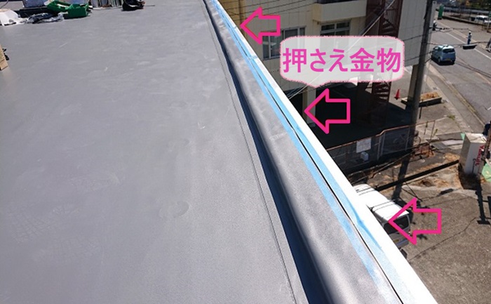 神戸市西区の陸屋根ゴムシート防水の改修工事で押さえ金物を取り付けている様子