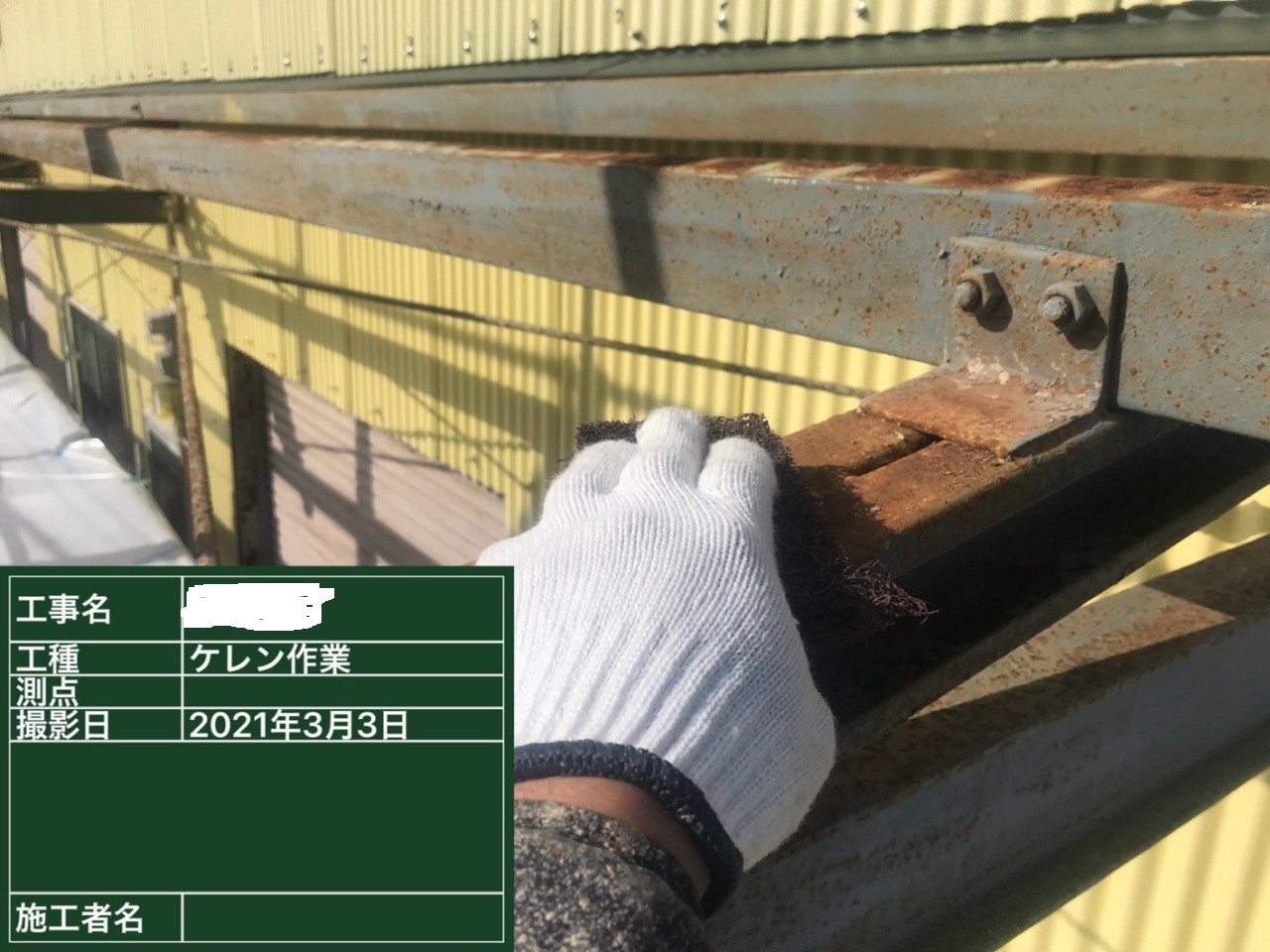 スレート波板屋根の鉄骨下地をケレンしている様子