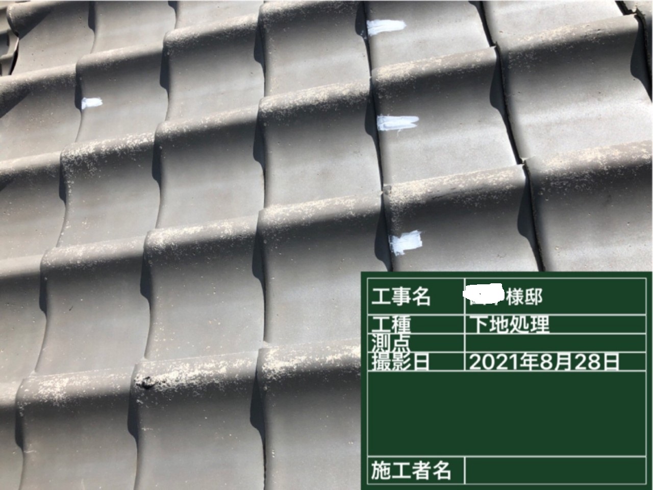 セメント瓦の細かいひび割れをコーキング補修している様子