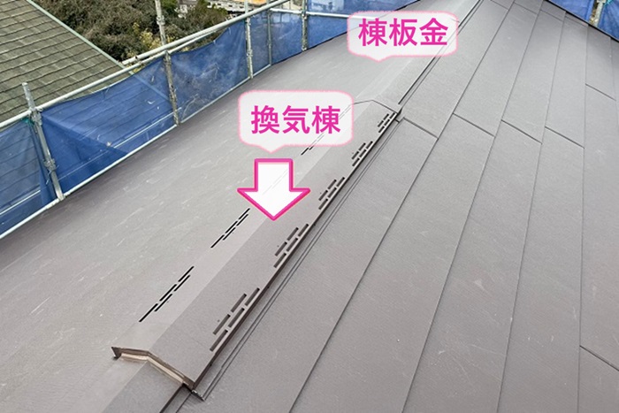 ノンアスベストスレート屋根の全面改修工事で棟板金と換気棟を取り付けている様子