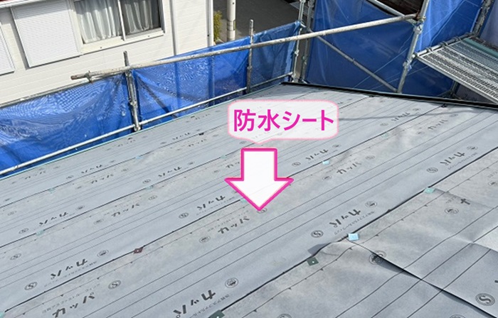 ノンアスベストスレート屋根の全面改修工事で防水シートを貼っている様子