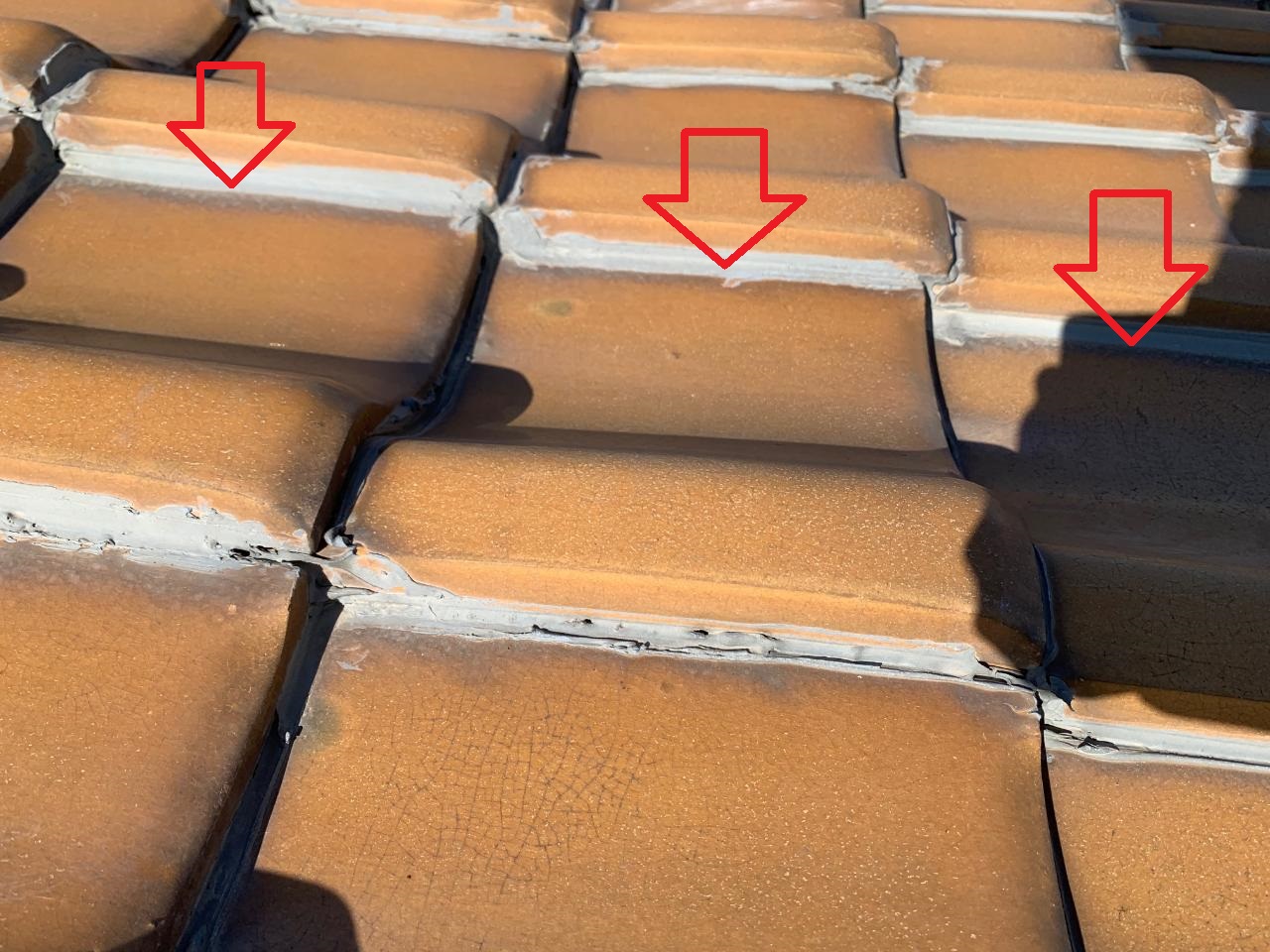 瓦屋根の補修でコーキングを打っている様子