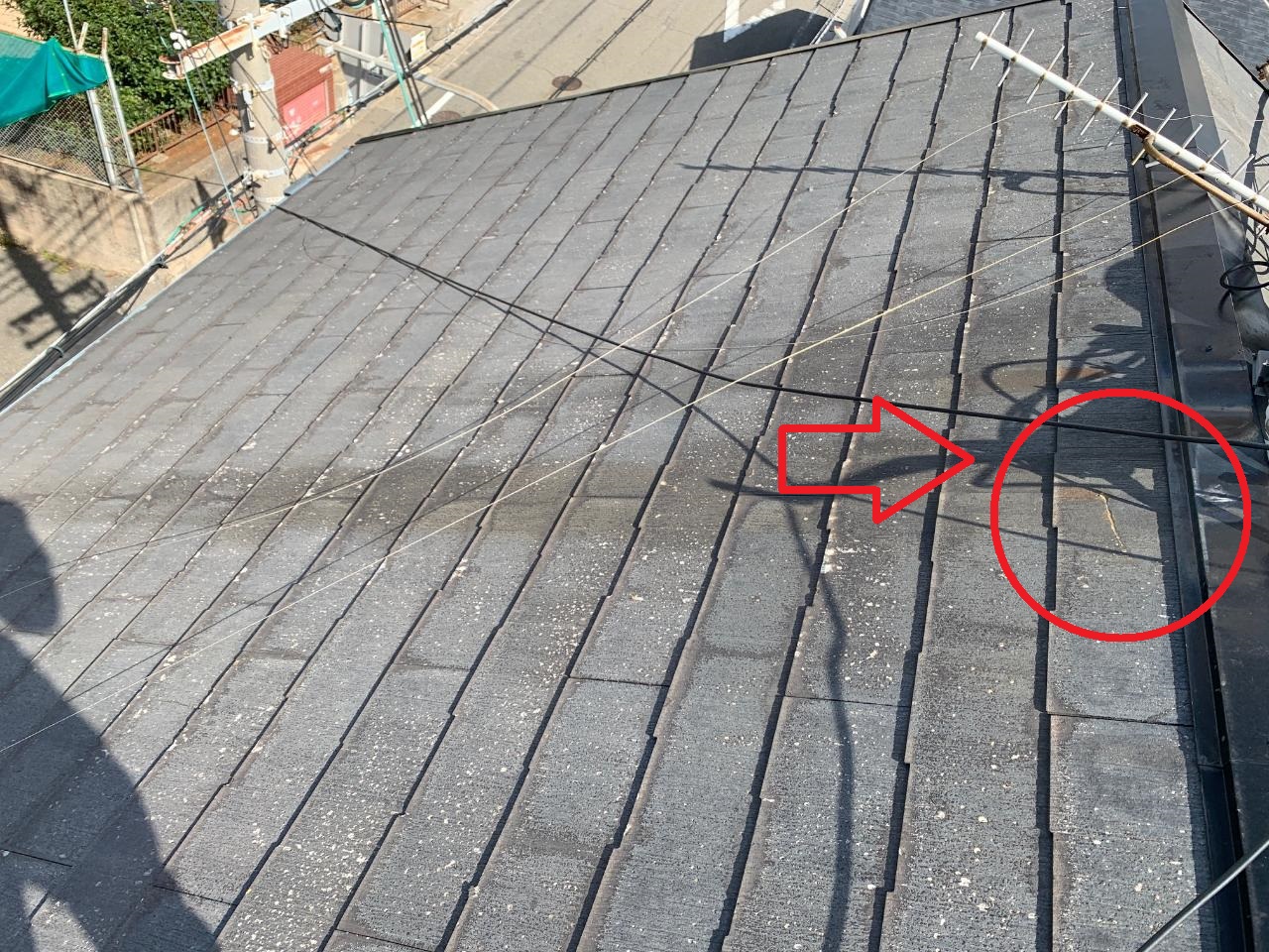 台風により屋根上のアンテナが倒壊してスレート屋根がひび割れている様子