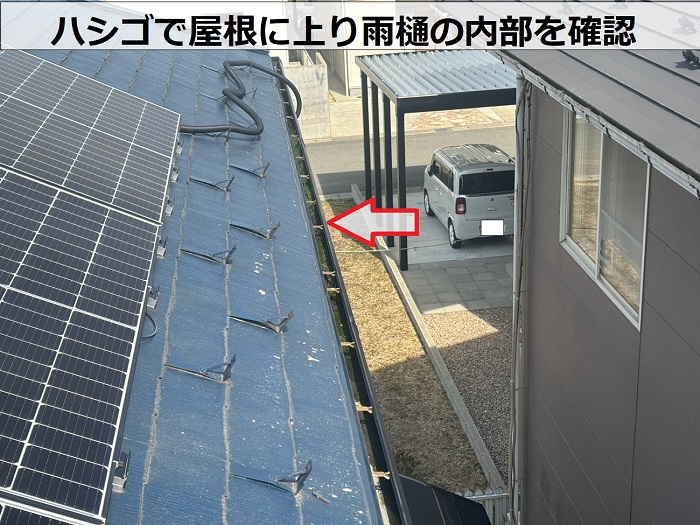 軒樋の状態を確認している様子