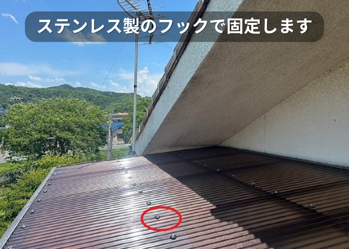 市川町 2階ベランダ屋根の貼り替えで波板をステンレス製のフックで固定している様子