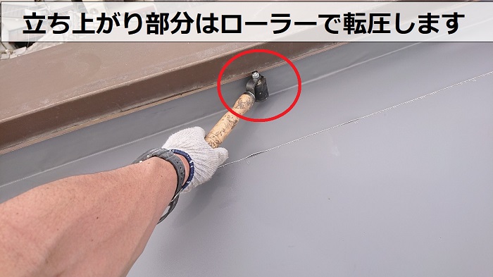 4階建てハイツの雨漏り修理で塩ビシート防水を転圧している様子