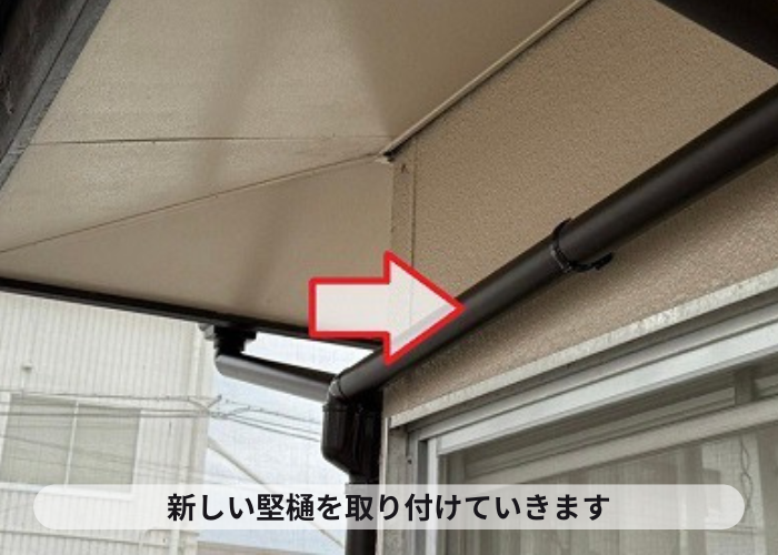 宝塚市での雨樋工事で新しい竪樋を取り付けている様子