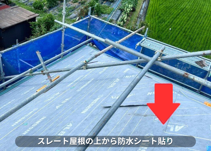 朝来市　スレート屋根の上から防水シートを貼っている様子