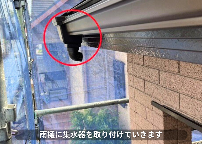 朝来市 雨樋に集水器を取り付けている様子