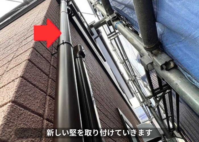 朝来市 雨樋交換で新しい竪樋を取り付けている様子