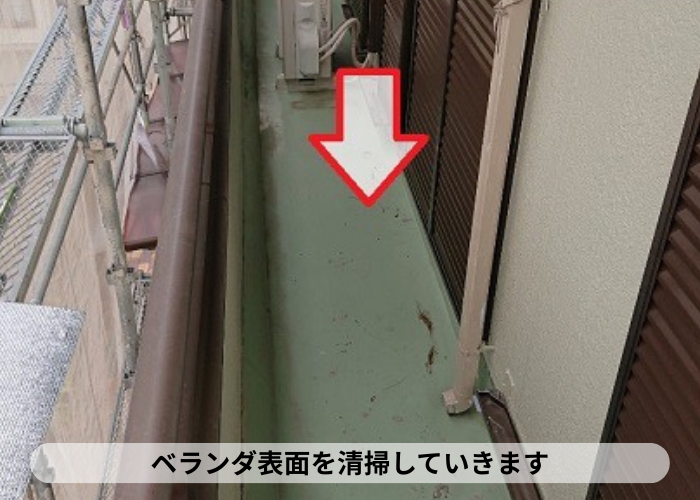 丹波篠山市 ベランダシート防水の改修工事で表面を清掃している様子
