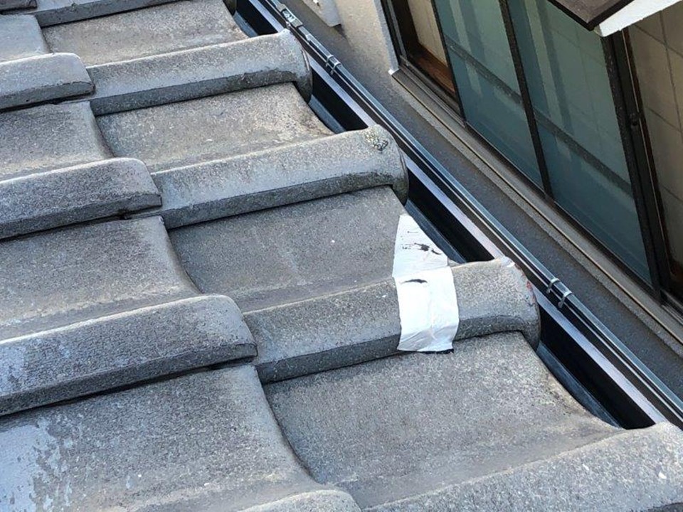 破損した瓦に養生テープが貼られている状態
