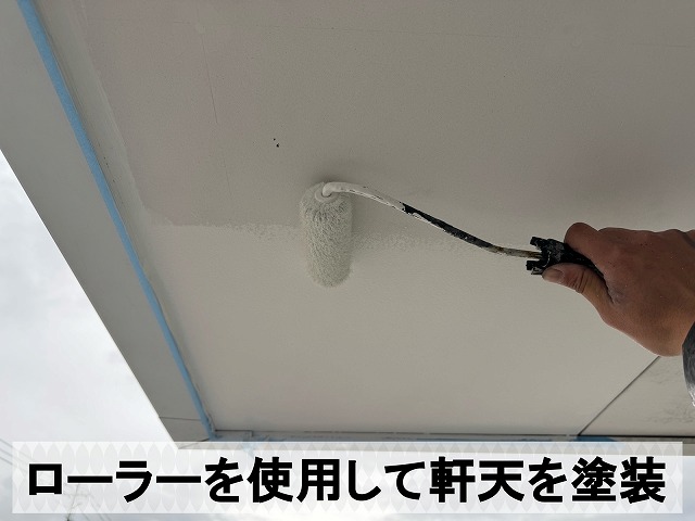 ローラーを使用して軒天の塗装を行っている状態