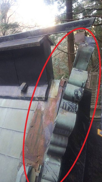 神社の銅板の鬼が傾いている