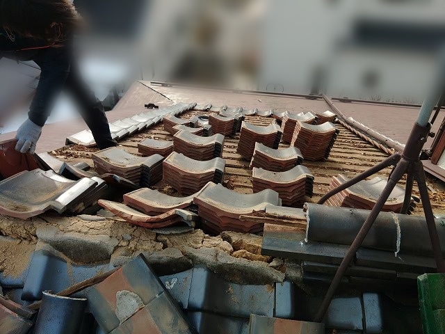 いわき市の二階建ての住宅の瓦屋根を解体しているところ
