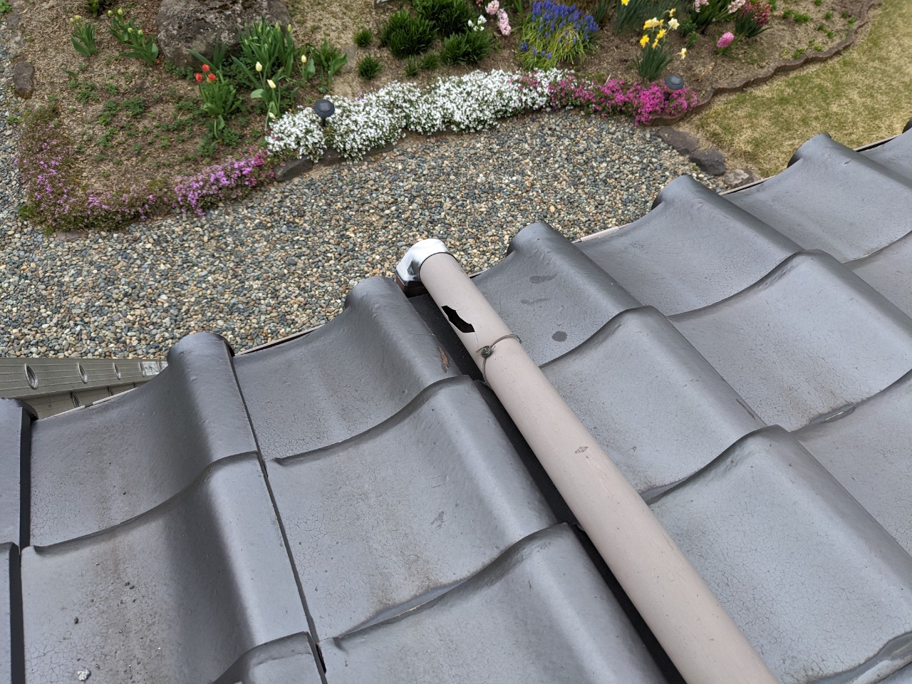 瓦屋根にかかる軒樋が破損し穴があいている