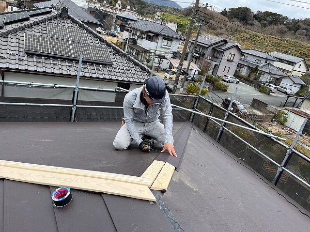 棟板金をビスで止めている