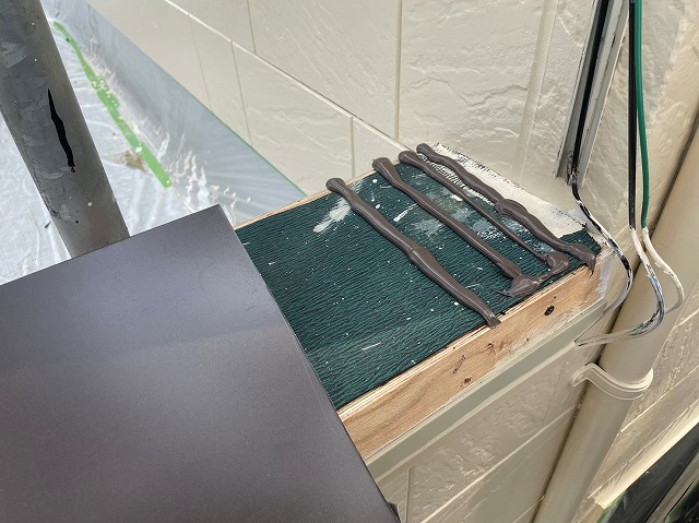 笠木を取り付けるためコーキング剤を塗布している