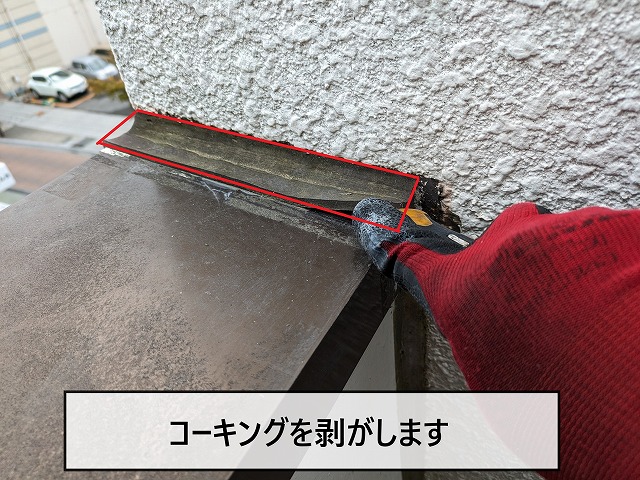 笠木部分のコーキングを剥がしている
