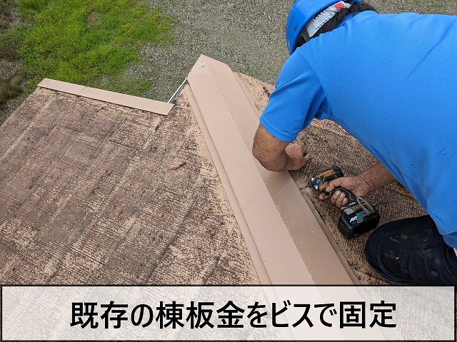 既存の棟板金をビスで固定しているところ
