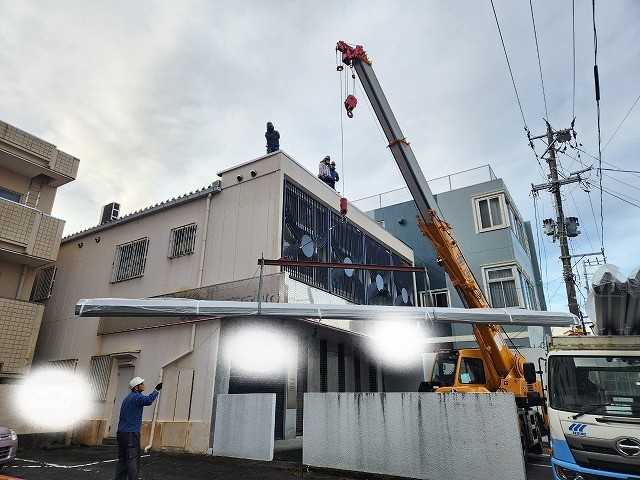 屋根材をクレーンで荷揚げしているところ