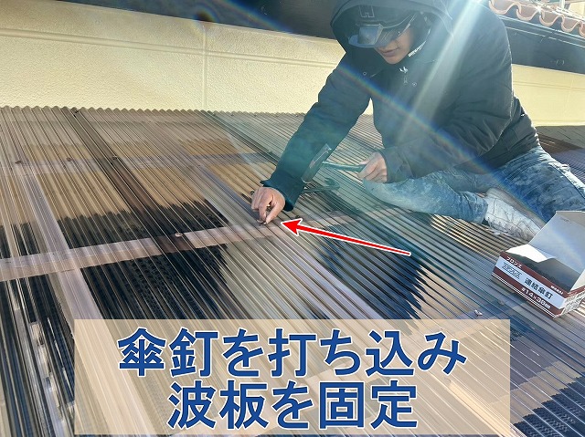 福島県いわき市　新しい屋根材の波に傘釘を打ち込んで固定しているところ