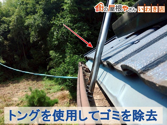 福島県いわき市　雨どいに溜まったごみをトングを使用して除去している状態