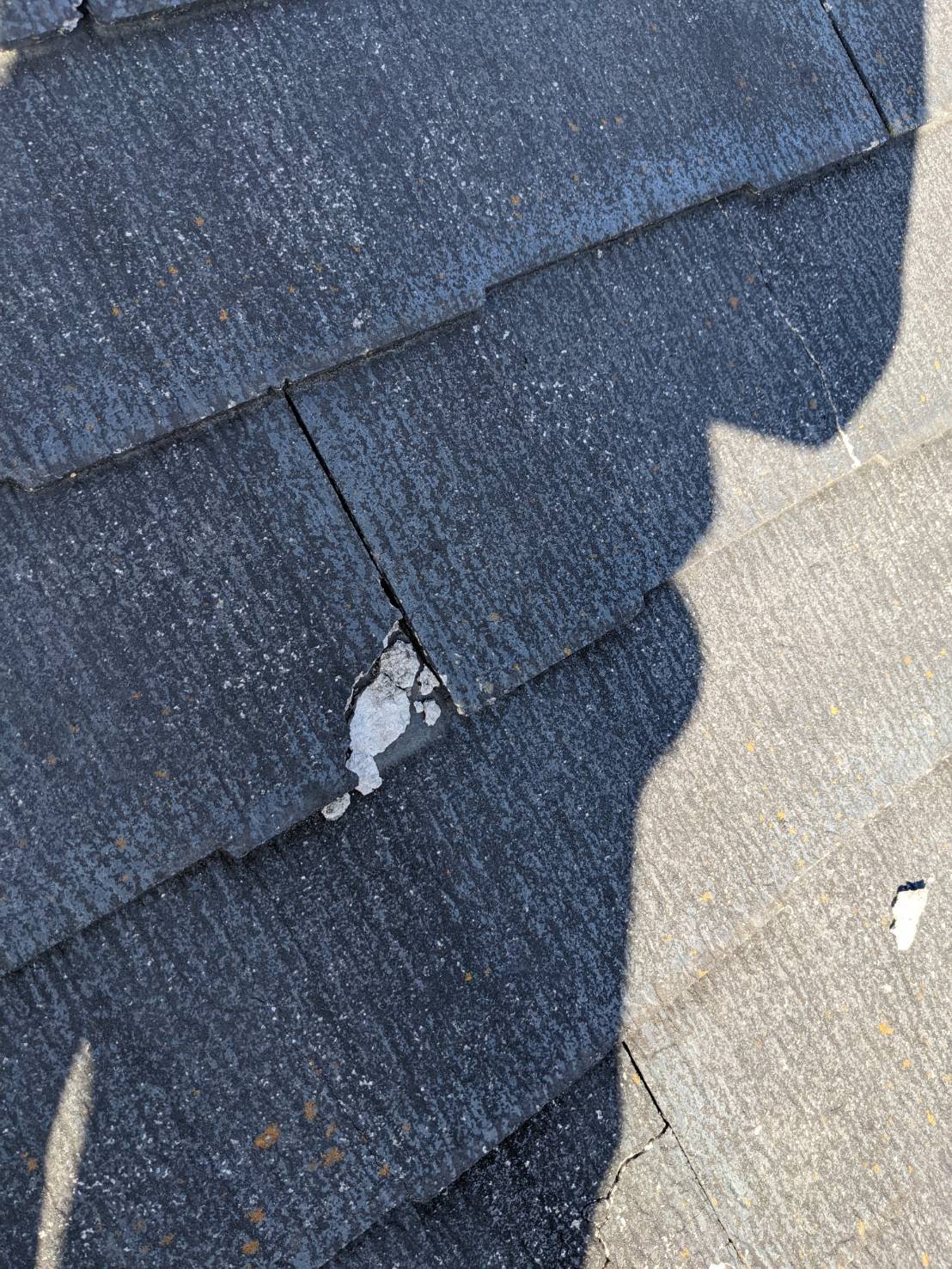 スレート屋根が欠けていて変色が見られる