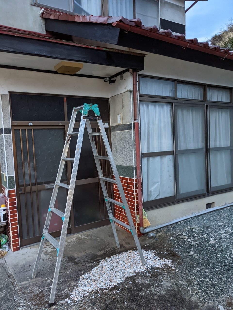 玄関の前に脚立を立てている