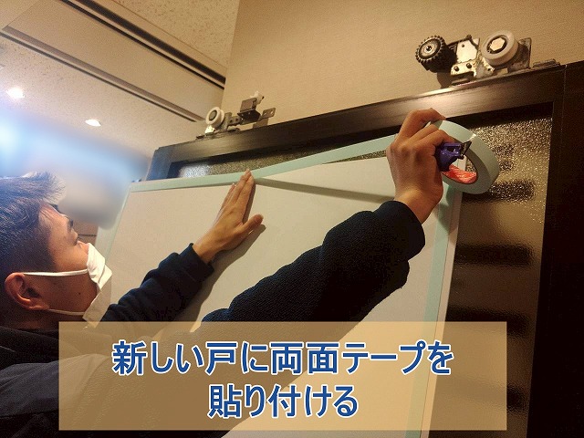 新しい戸に両面テープを貼りつける
