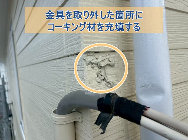 取り外した電線取り付け板にコーキング材を充填している様子