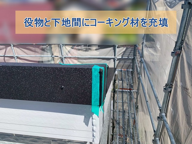 板金役物と下地の間にコーキング材を充填している様子
