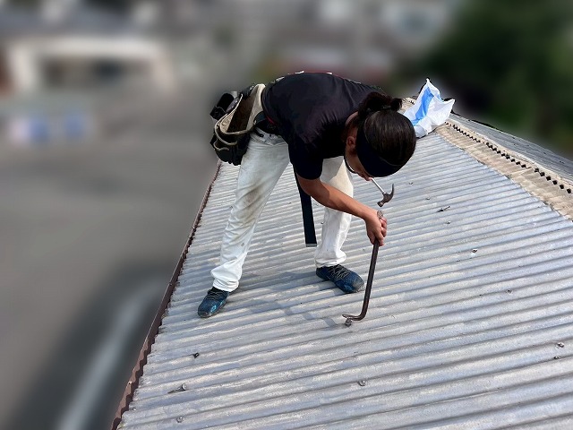 既存の金属トタン屋根材を撤去している様子