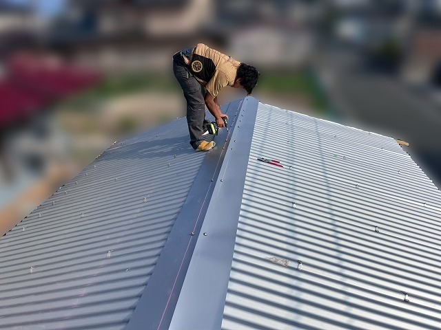 金属トタン屋根の棟板金を固定している様子