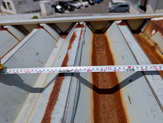 金属折板の幅の測定を行っているところ