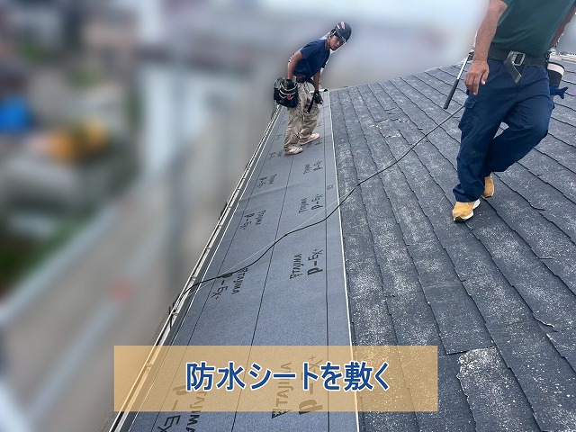 防水シートを敷いている作業員